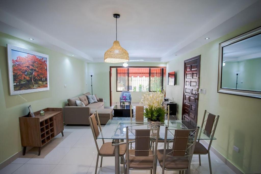 comedor y sala de estar con mesa de cristal y sillas en Amplio apartamento en zona exclusiva con parqueo, en Los Prados