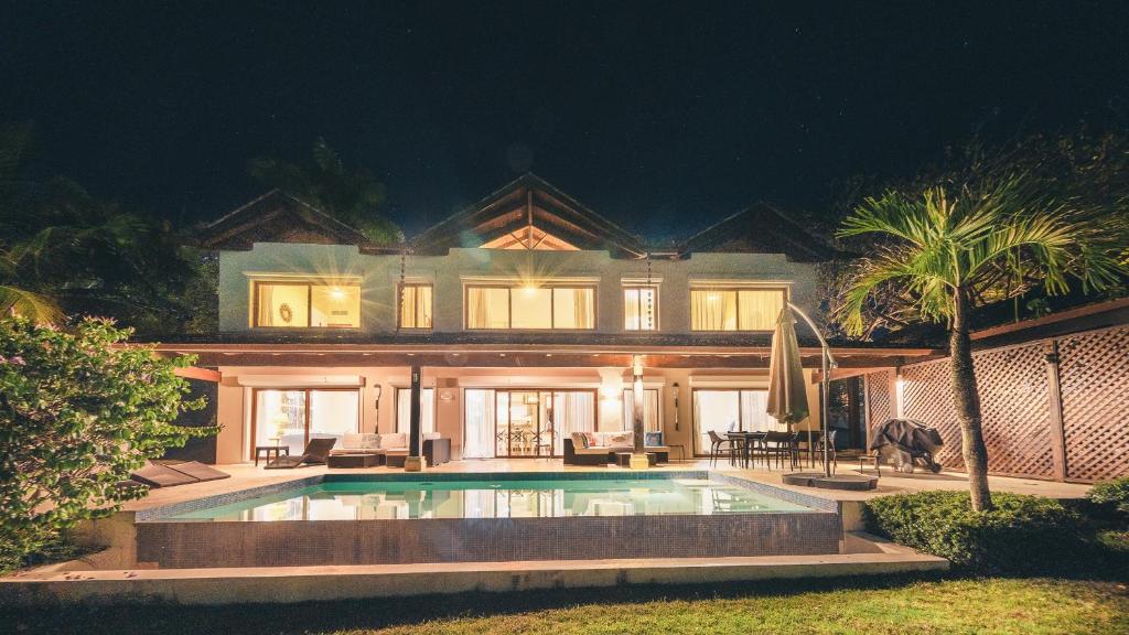 une grande maison avec une piscine la nuit dans l'établissement Luxurious Villa at Puerto Bahia with Great Views, à Santa Bárbara de Samaná
