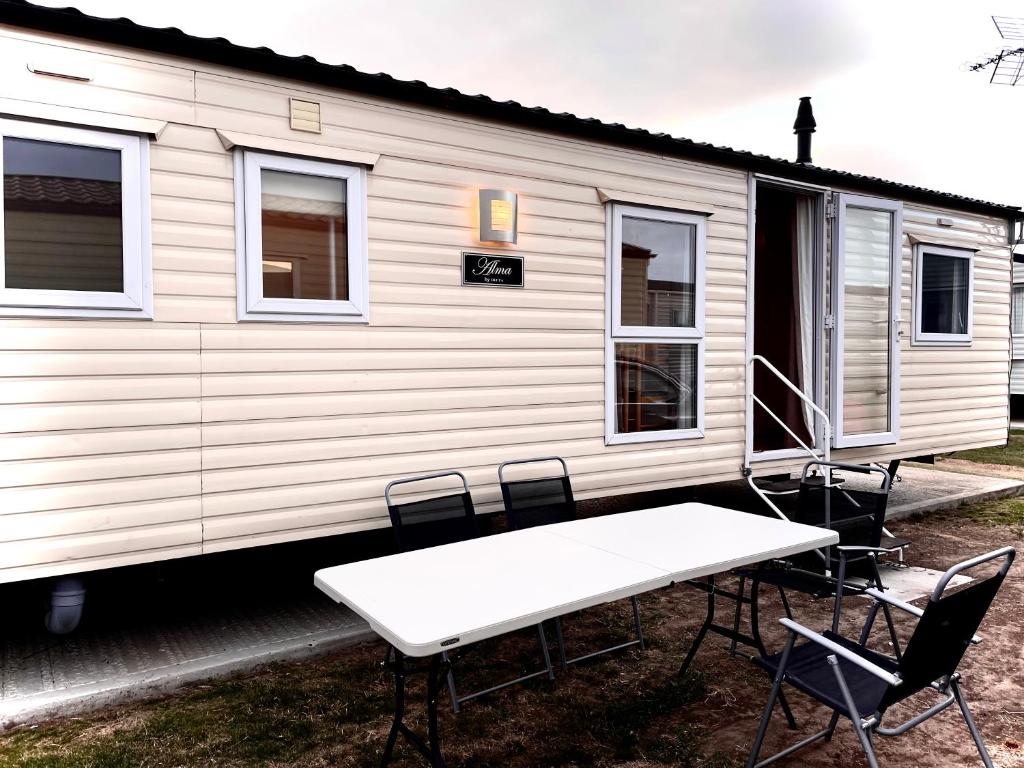 a table and chairs in front of a mobile home at Impeccable 4-Bed Caravan in Clacton-on-Sea in Clacton-on-Sea