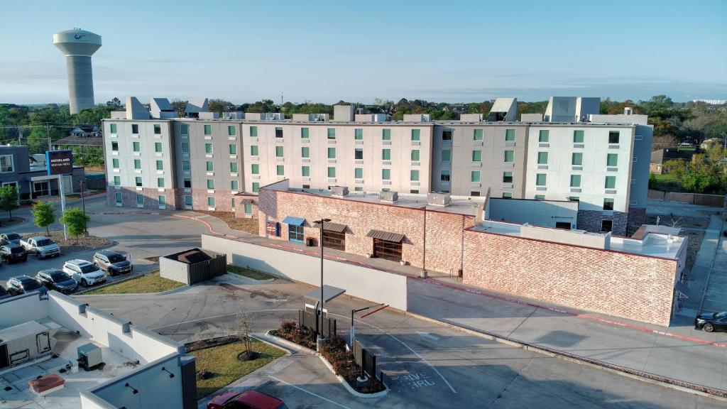 an aerial view of a large building with a parking lot at voco College Station Aggieland by IHG in College Station