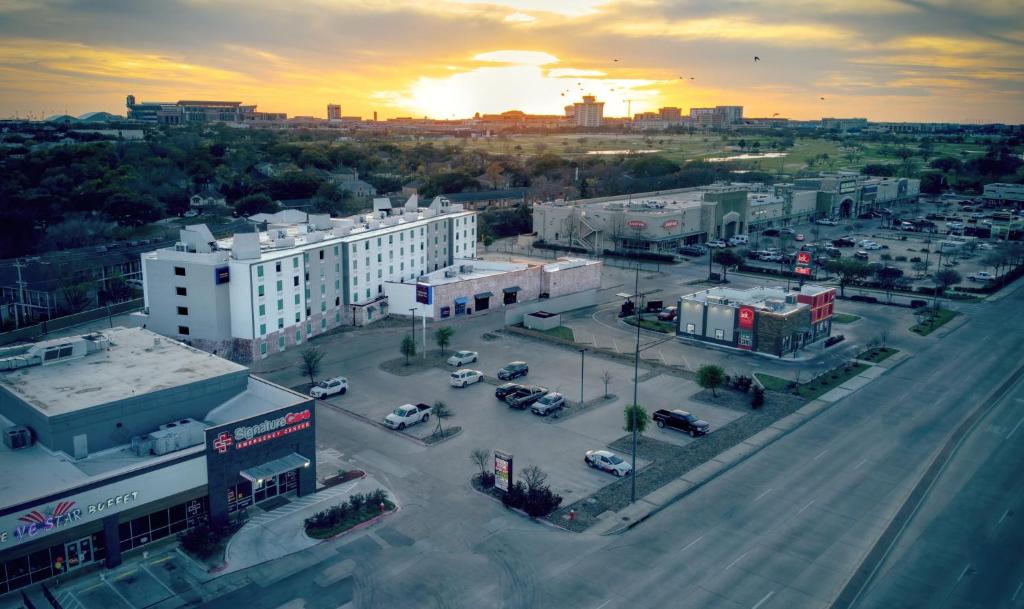 a city with cars parked in a parking lot at Aggieland Boutique Hotel in College Station