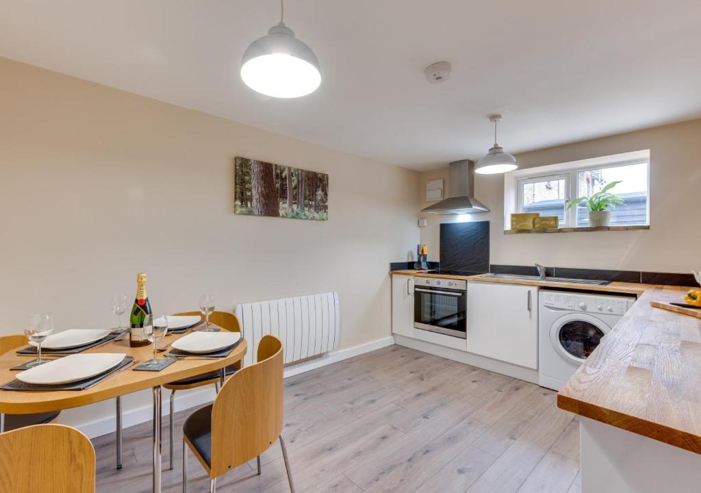 a kitchen and dining room with a table and chairs at Ardley Cottage Badger in Waldingfield