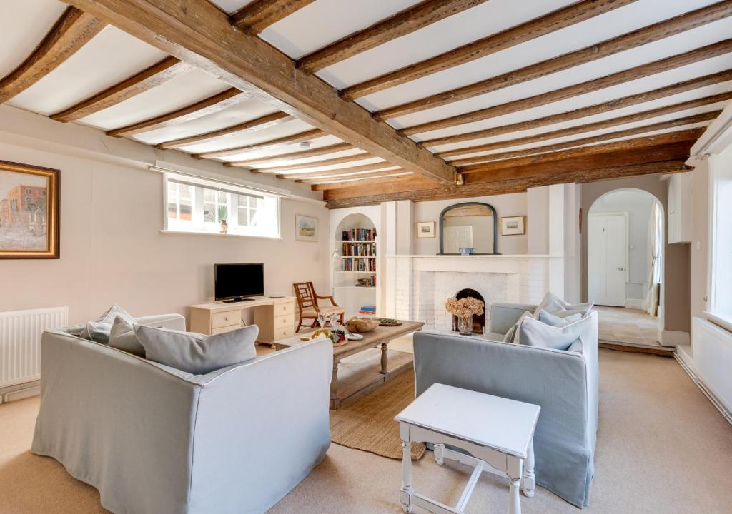 Elle comprend un salon doté d'un mobilier blanc et d'un plafond en bois. dans l'établissement Rest Cottage, à Southwold