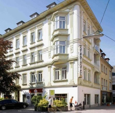 un gran edificio blanco con un cartel. en Stadthotel Hauser Eck, en Sankt Pölten