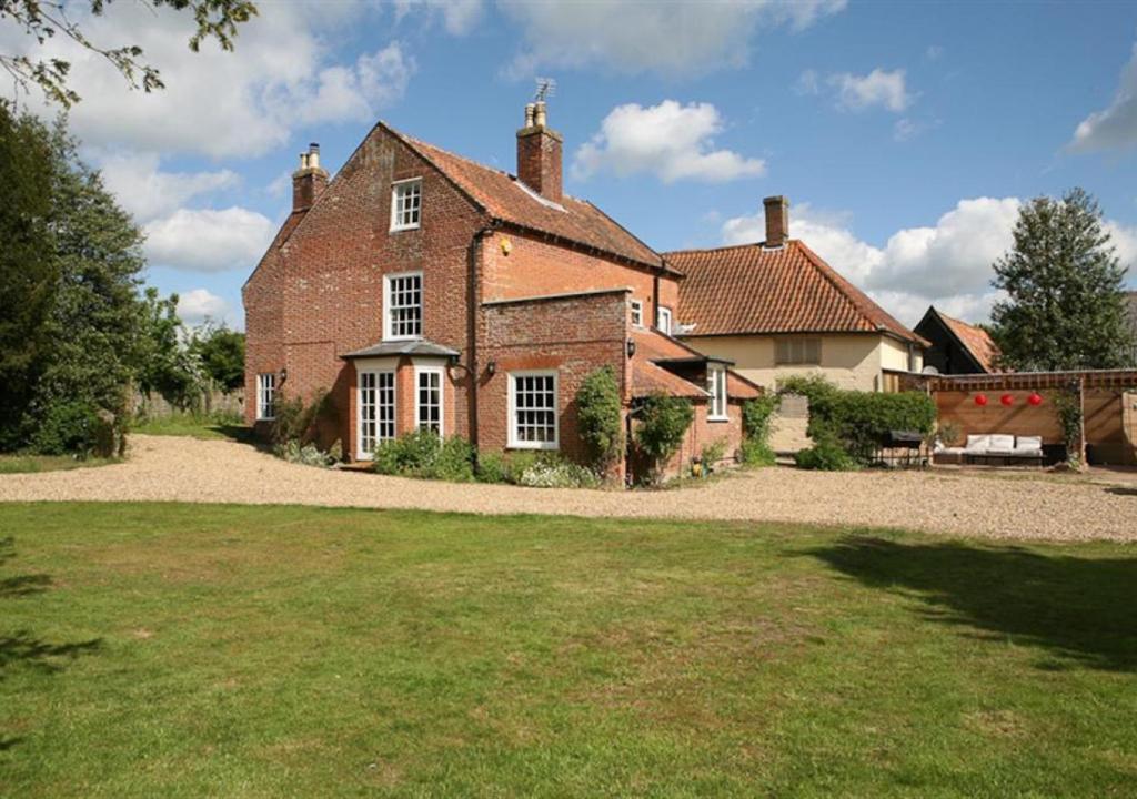 a large brick house with a large yard at The Manor House in Bramfield