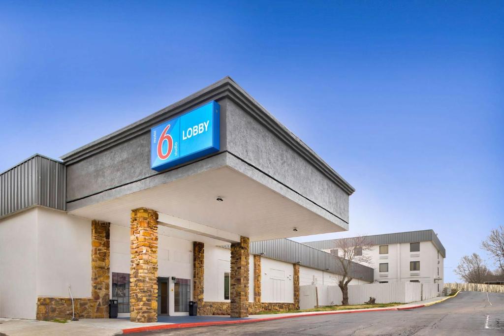 a building with a gas station sign on it at Motel 6 - Bartlesville, OK in Bartlesville