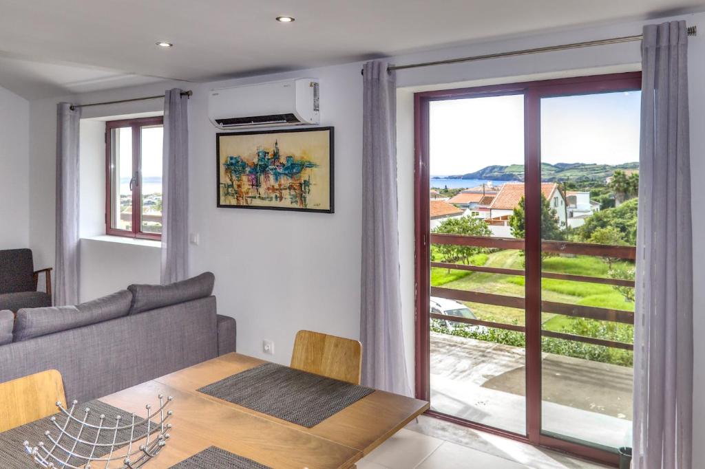 sala de estar con mesa y ventana grande en Great View Apartment AL, en Porto Martins