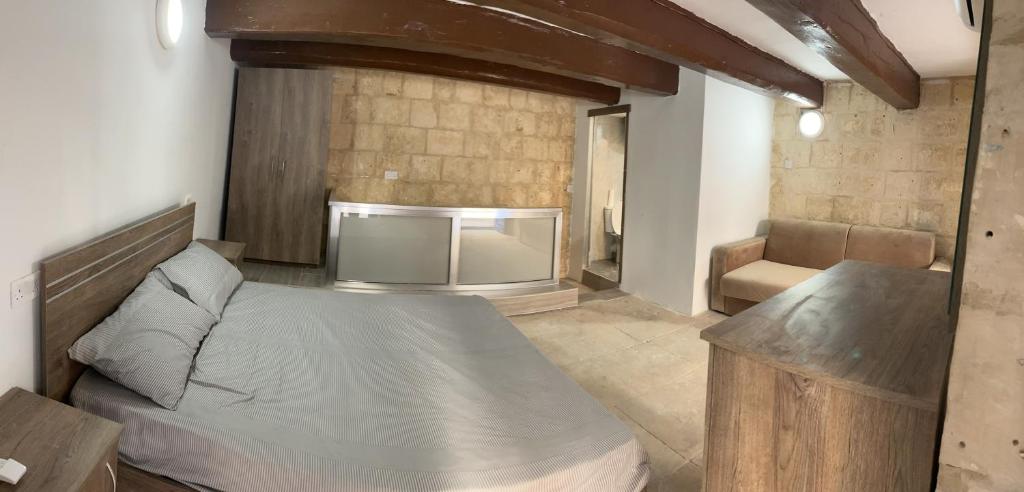 1 dormitorio con 1 cama y TV. en Traditional Townhouse In The Hearth Of Valletta en La Valeta