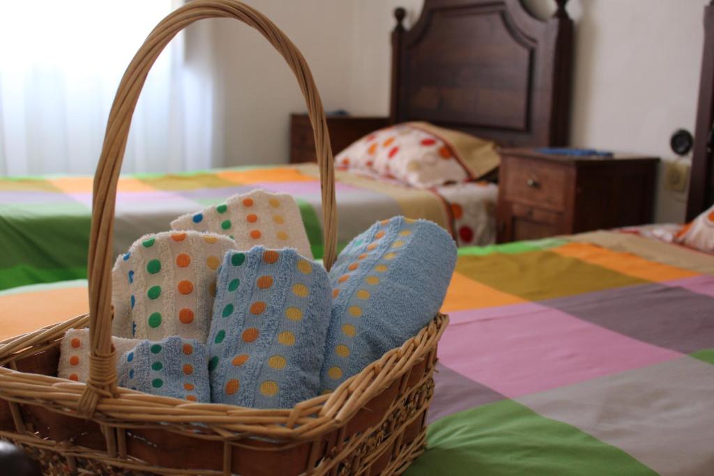 a basket filled with socks sitting on a bed at Fernando Guest House in Aveiro