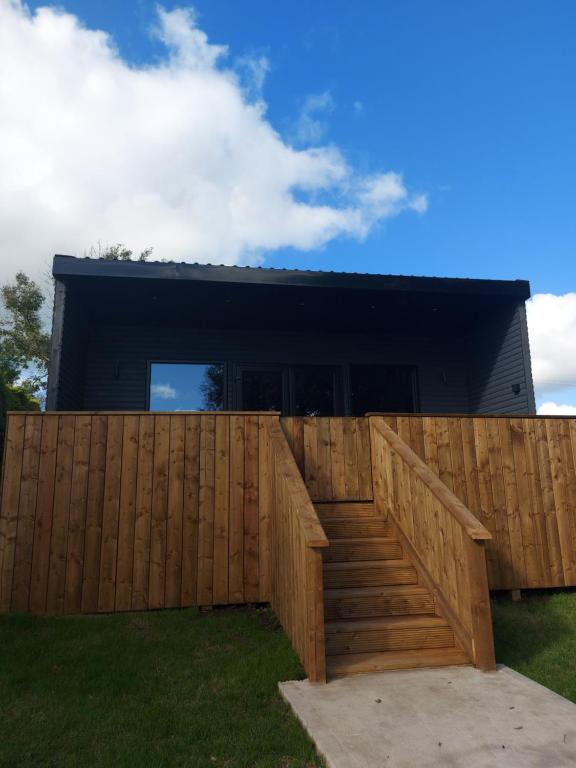 una recinzione di legno di fronte a una casa di Lough View Lodge a Dunnamanagh