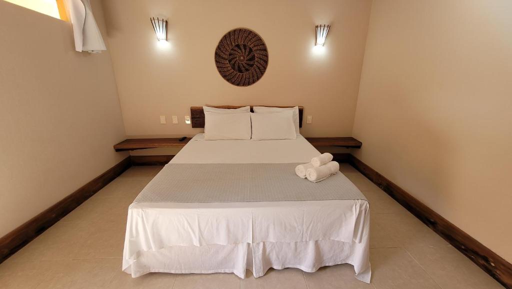 un dormitorio con una cama con un animal de peluche en Pousada Aquário, en Isla de Boipeba