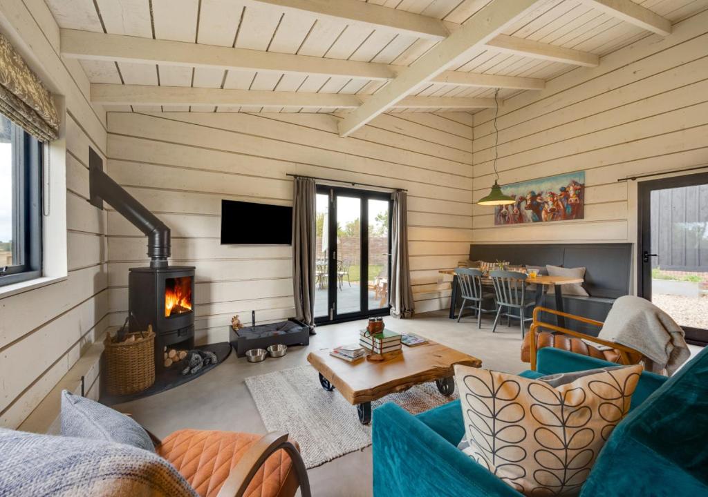 a living room with a couch and a fireplace at The Cowshed in Crowfield