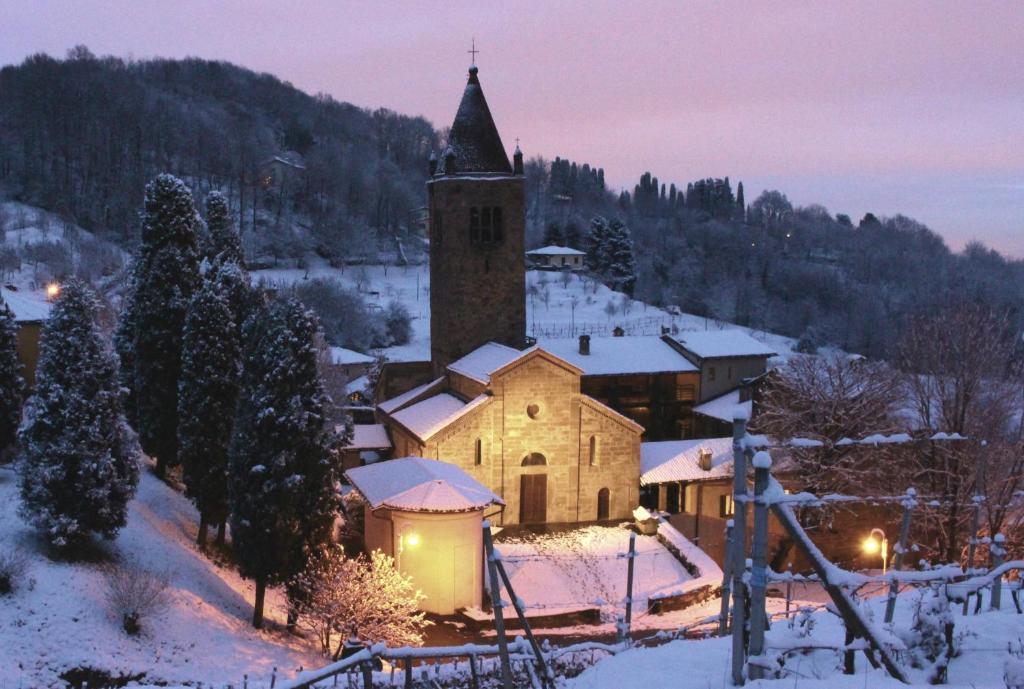 Sotto il Monte的住宿－阿爾基奧斯特羅中世紀修道院歷史公寓，夜间雪中的小教堂