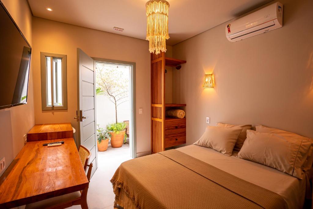 a bedroom with a bed and a table and a window at Casa Savana in Sao Paulo