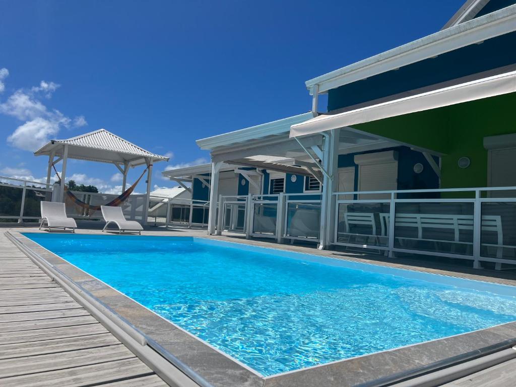 une piscine avec deux chaises à côté d'une maison dans l'établissement Villa de Standing avec piscine au Gosier, au Gosier