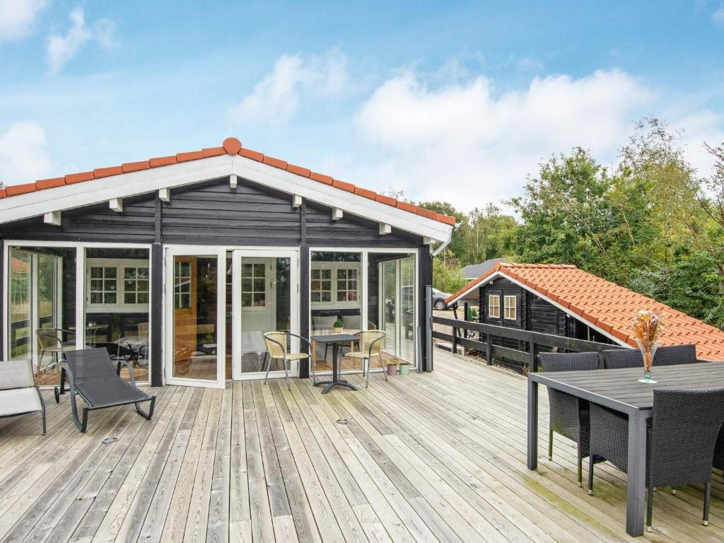 a pavilion with a deck with a table and chairs at Holiday home Toftlund XLIV in Toftlund