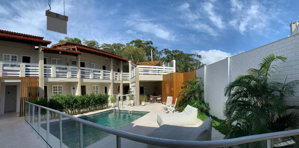um pátio com uma piscina e um edifício em Hotel Geranius Ingleses em Florianópolis