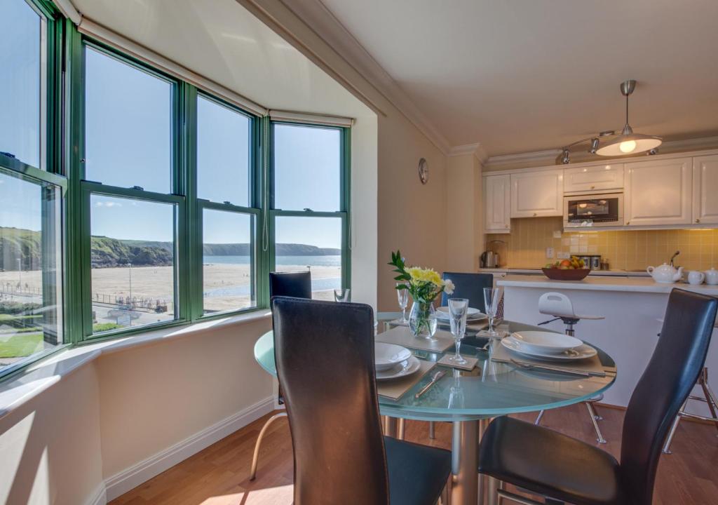 a kitchen and dining room with a table and chairs at 32 St Brides Bay View Apts in Broad Haven
