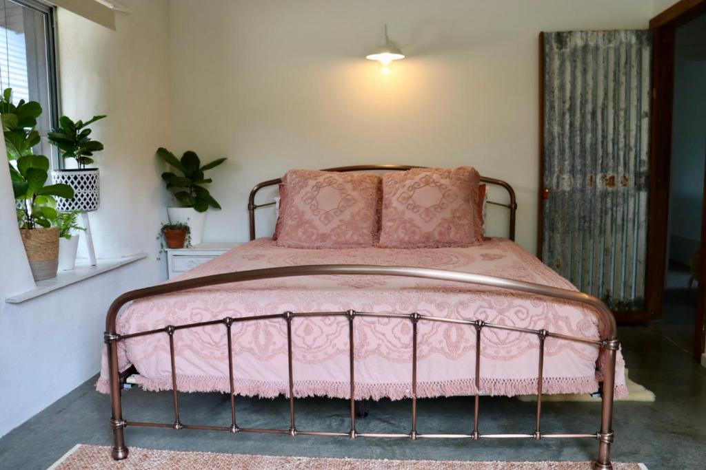 um quarto com uma cama rosa e um cobertor rosa em EcoLuxe em Dunsborough