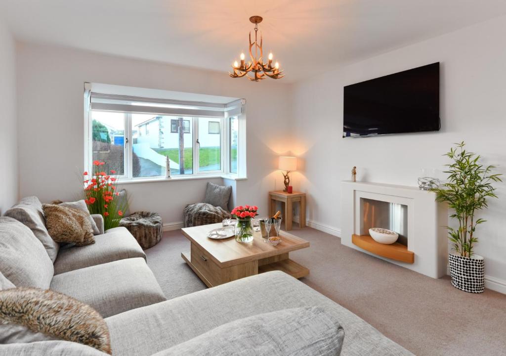 a living room with a couch and a fireplace at 78 Cae Du in Abersoch