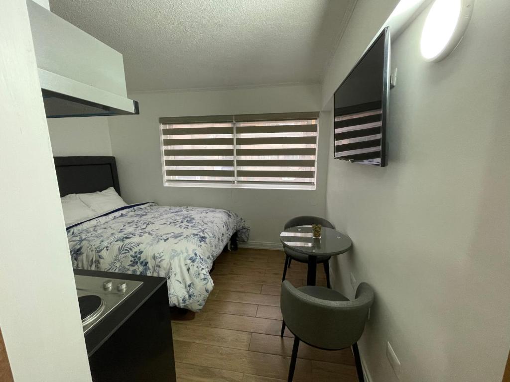 Dormitorio pequeño con cama y lavamanos en TinyApartments - estudio pleno centro Concepción en Concepción