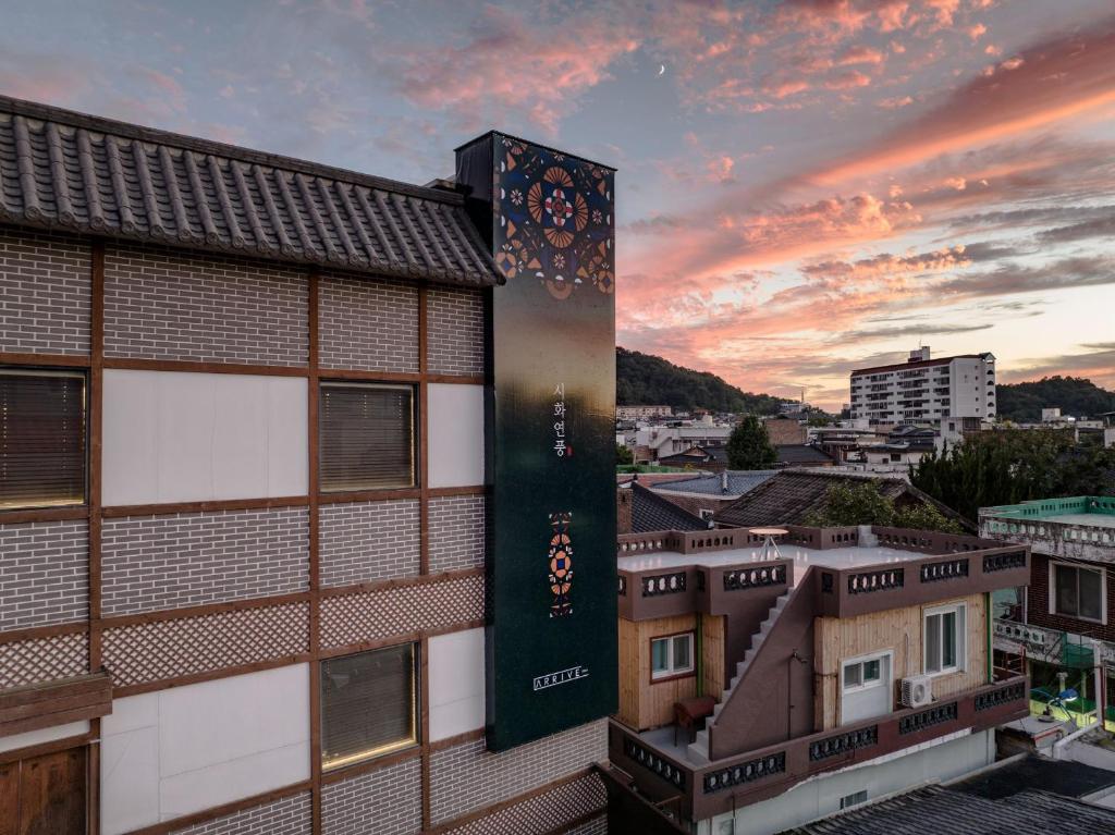 a view of a building with a sunset in the background at HotelArrive Jeonju Sihwayeonpung in Jeonju