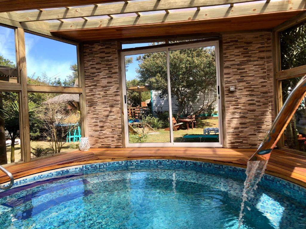 a swimming pool in a house with a large window at Posada Agua Marina in La Paloma