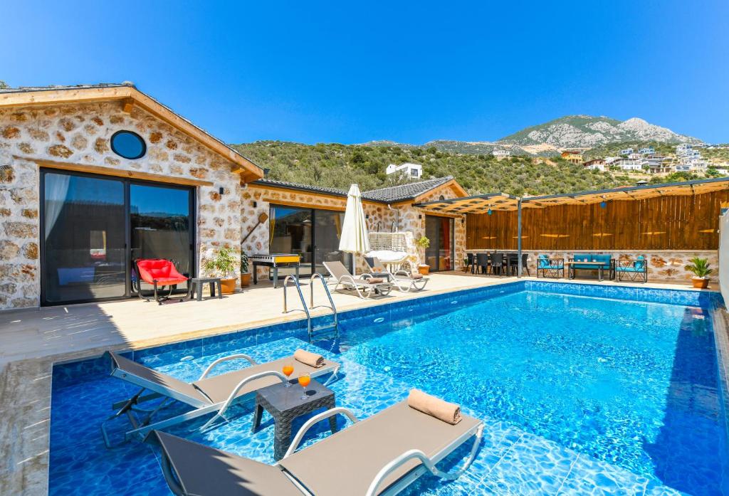 eine Villa mit einem Pool und einem Haus in der Unterkunft Havuzu dışarıdan görünmeyen jakuzili özel havuzlu lüks villa in Kalkan