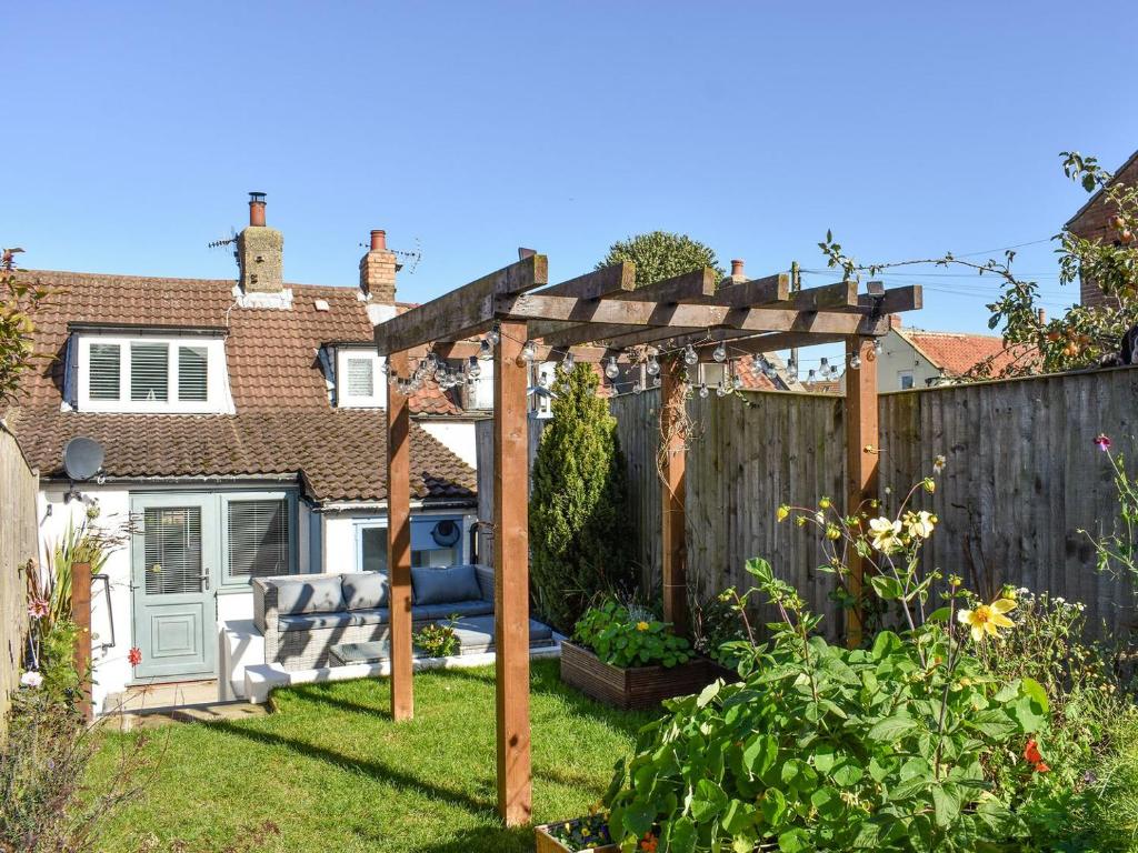 a garden with a pergola and a fence at Bay Cottage in Cayton