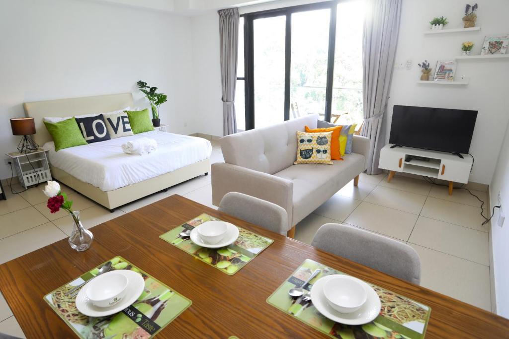 een woonkamer met een bed, een tafel en een bank bij LOVELY & COZY HOME @ MIDILLS GENTING in Genting Highlands