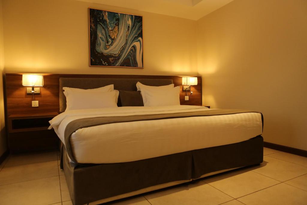 a bedroom with a large bed with two lights at المهيدب للوحدات السكنيه - البوادي in Jeddah