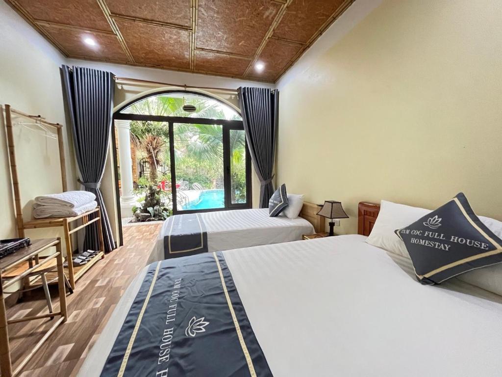 a bedroom with two beds and a window at Tam Coc Full House Homestay in Ninh Binh