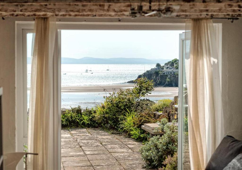 a room with a view of the beach from a window at Glanaber Bach in Abersoch