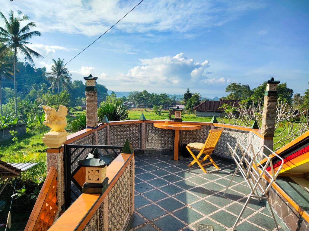 a patio with a table and chairs on a balcony at Dau Homestay in Tirtagangga