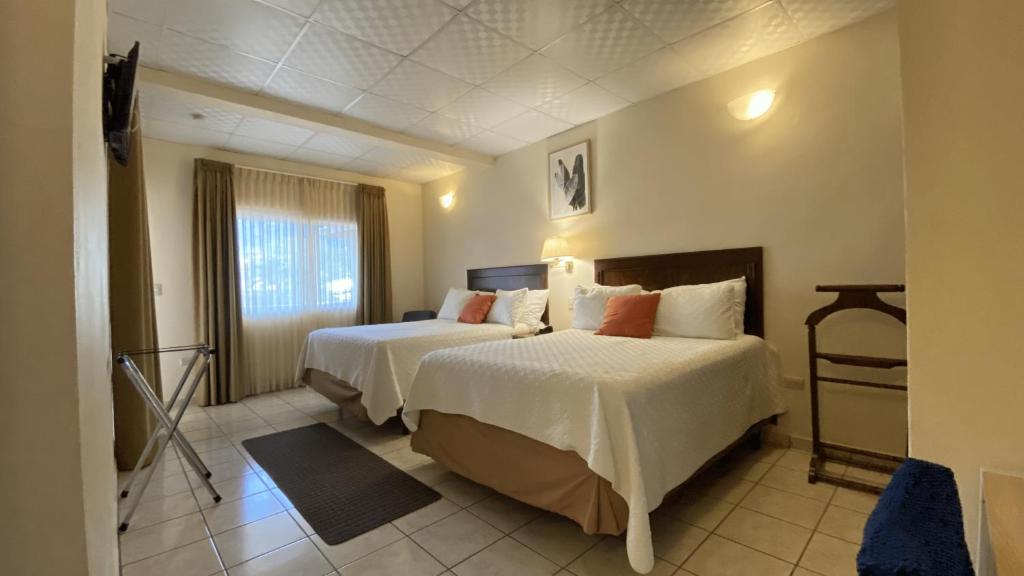 una camera d'albergo con due letti e una finestra di Real Guanacaste a San Pedro Sula