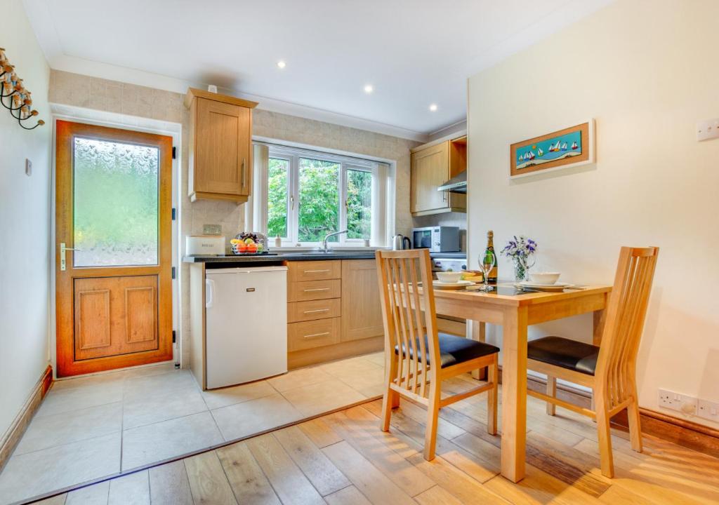 uma cozinha com uma mesa e cadeiras de madeira e uma mesa em Hallstatt em Saundersfoot