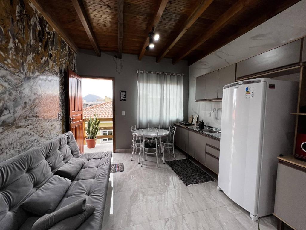 uma sala de estar com um sofá e uma mesa numa cozinha em Moradas Desterro, próximo ao aeroporto 24 em Florianópolis
