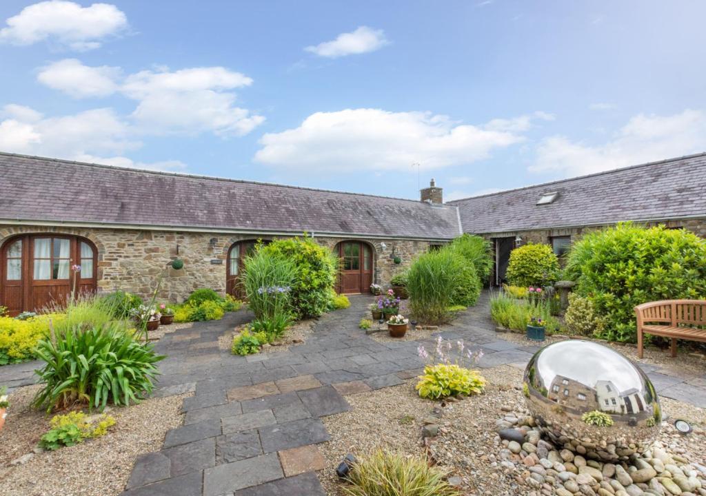 a garden in front of a stone house at Primrose Cottage in Haverfordwest