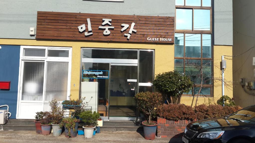 a cafe house with a sign on the front of it at Minjoonggak in Seogwipo