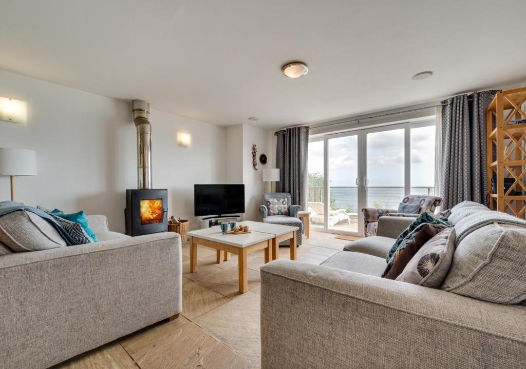 a living room with two couches and a fireplace at Sunridge in Amroth