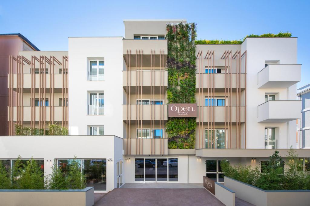 un edificio de apartamentos con un jardín vertical en la fachada en Open Hotel en Rímini