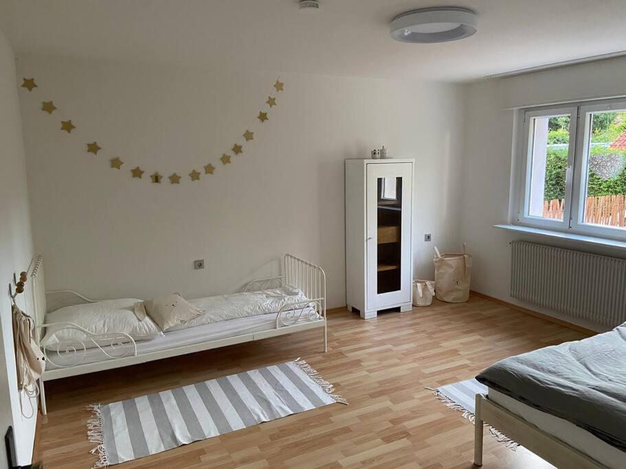 een witte kamer met een bed en een spiegel bij SCHÖNE HELLE FERIENWOHNUNG in Wehr