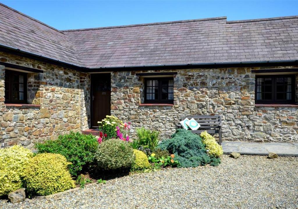 a stone house with a garden in front of it at Wishing Well in Walton West