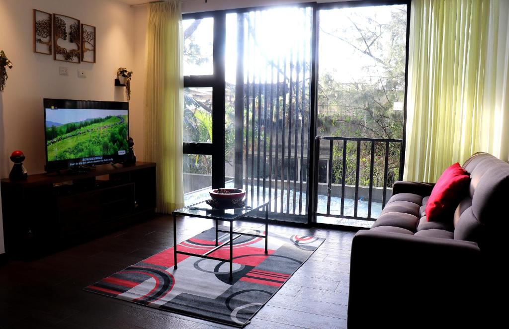 a living room with a couch and a television and a balcony at Estancia PET FRIENDLY con parqueo y WIFI Gratis in Guatemala