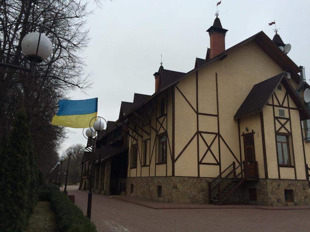 un edificio con una bandera delante de él en Pan Otaman, en Pisarevka