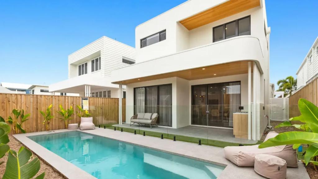 a house with a swimming pool in front of it at Beach Life Luxury Escape Kingscliff in Kingscliff