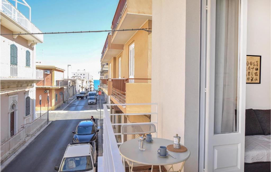a balcony with a table and a view of a street at 1 Bedroom Nice Apartment In Pozzallo in Pozzallo