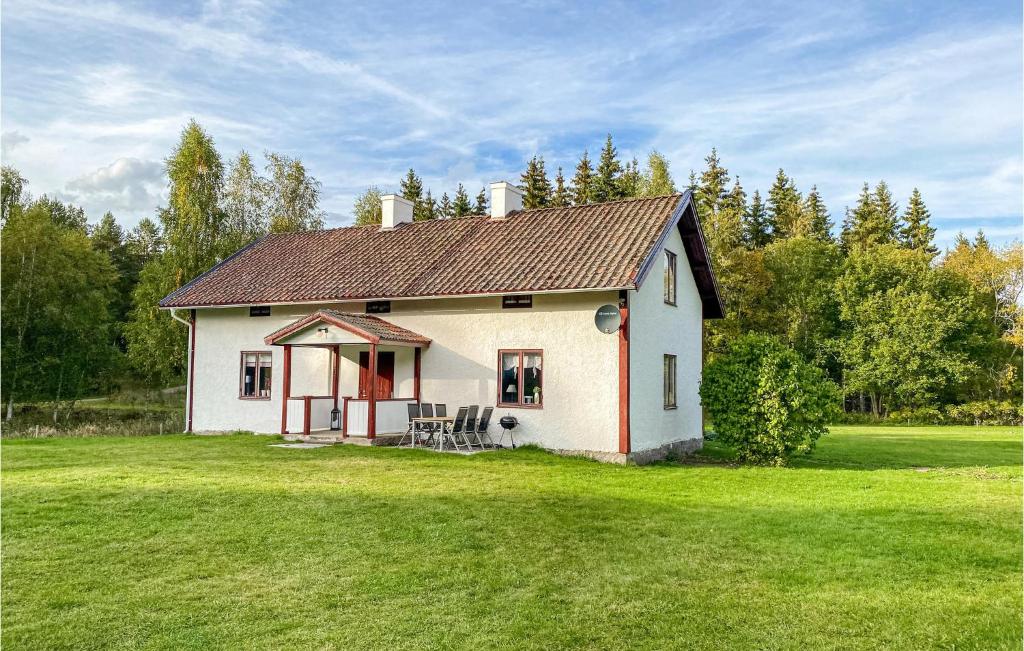 una pequeña casa blanca con un patio de césped en Nice Home In Boxholm With Kitchen, en Boxholm