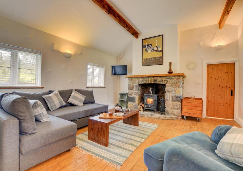 a living room with a couch and a fireplace at Ty Rowan in Trefriw