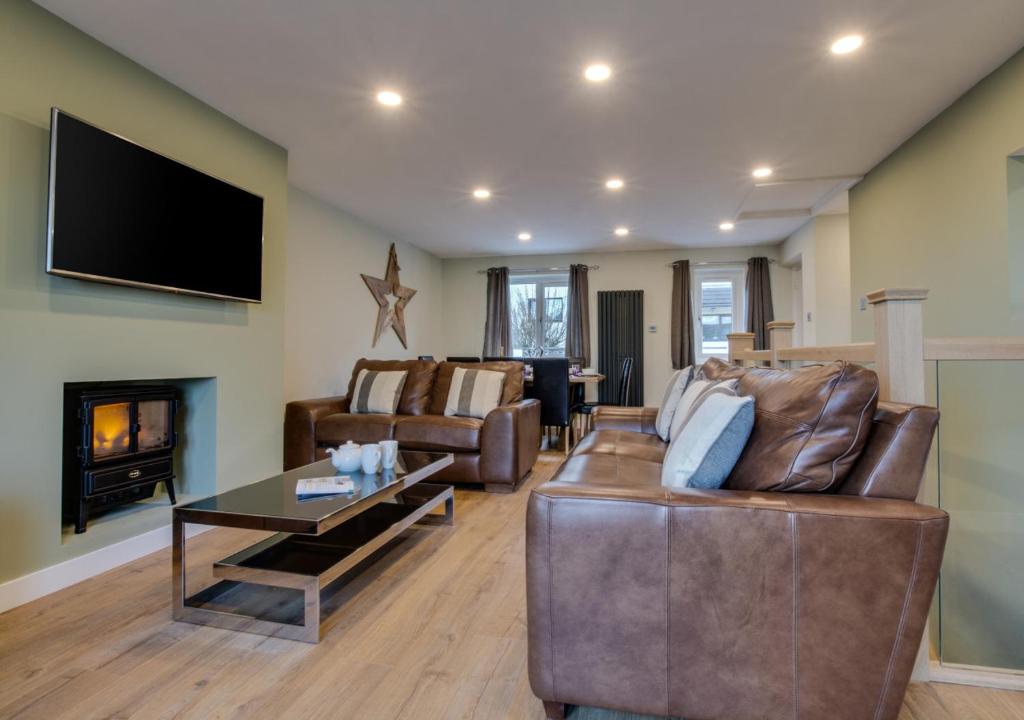 a living room with a couch and a fireplace at The Retreat in Saundersfoot